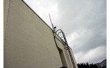 小学校の屋上に設置されていた2本のアンテナ。横浜ではセクターアンテナという120度角のアンテナを設置しているが、受信のダイバーシティーをとるためにオムニアンテナを2本つけているの画像