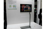 11型のXEL-1に比べると破格に大型化した27型有機ELテレビ（参考出品）。しかし、大画面液晶のBRAVIAシリーズが並ぶ同社ブースの中でかなり小く感じるの画像