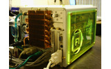 緑の蛍光色に光るキューブPC。背面には水冷型と思われる冷却装置がつけられているの画像