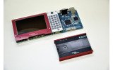 :本体にデバッグ用インターフェイスボードを装着したところ、JTAGエミュレータなどはこのボードを経由して接続する。下の箱はソフィアシステムズのエミュレータEJSCATT。セット販売も予定されているの画像