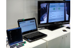 左下の青いボックスがDLNA対応メディアコントローラー一体型のフェムトセル基地局。携帯電話（ここではiPhoneを利用）からの操作で、ホームネットワーク上にあるコンテンツをノートPCやテレビなど好みの画面で再生可能の画像