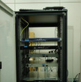 YRP1番館の4階の実験室にあるラックに基地局を制御する専用装置を収納。検証無線ネットワークとコアネットワークが構築されている