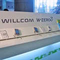 ウイルコムの体験コーナー。本日発売のW-OAM対応超小型通信モジュール「W-SIM」も展示されている。その他、NTTドコモとソフトバンクモバイルもそれぞれ体験コーナーを設け、担当スタッフが説明にあたる