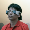 モバイル端末がメガネ型になった場合にテレビ電話機能を実現させるためのアイデアがこれ。計5カ所に装着されている超広角レンズで装着者の顔を撮影。