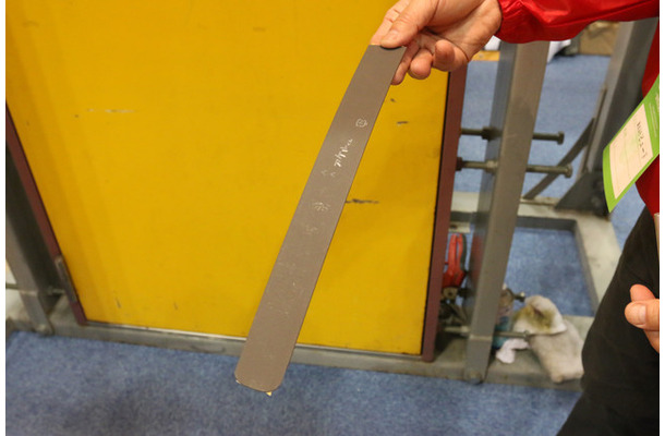 「アケルくん」は表面にスベリ材をコーティングした薄い樹脂製プレート。既存のドアに取り付けるだけで震災時の避難経路を確保できる（撮影：防犯システム取材班）
