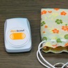 児童用のICタグ。右のお守り袋に入れて持たせる。ボタンを長押しすると緊急発報するの画像
