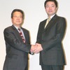 握手する松下電器の古池進副社長（左）とスクウェア・エニックスの和田洋一社長（右）の画像