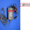 AC電源アダプタ（NBG-299A）の装置外観およびシール貼付位置の画像