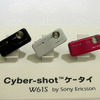W61S。5メガピクセルカメラ＋スマイルシャッター Liteを搭載。本家Cyber-shotの同機能に比べると、笑顔認識速度が若干遅いこと、対象が3人までとなる。ISO1600対応、手ぶれ補正、Blogアップ機能などの搭載を予定する。実動機の展示はなかったの画像