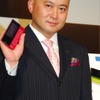 WILLCOM 03を手にする代表取締役社長の喜久川政樹氏の画像