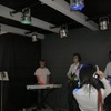 可視光通信を用いたエンターテインメント系のデモンストレーション。専用のヘッドホンを装着して、青の光の下に立つとベースの音が、緑はギター、赤はキーボードの音が聞こえる。これは、可視光に音の情報を載せてヘッドホンに送信しているの画像