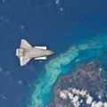 カリブ海のプロビデンシア島上空を飛行するスペースシャトル。国際宇宙ステーションへの第23次長期滞在に参加の宇宙飛行士　野口聡一氏による撮影（c）NASA