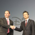握手を交わすNTTドコモ永田氏とウォルト・ディズニー・ジャパンのミルスタイン氏