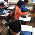 写真2　友達のリーフレットをiPadで開いて学ぶ子どもたち