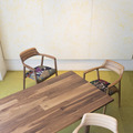 深澤直人がデザインした椅子「HIROSHIMA」（手前からビーチ。オーク、ウォルナット）に皆川明デザインのファブリックを座面に施したペシャルチェアと、端材をパッチワークして作った無垢天板のテーブル「MALNI」。