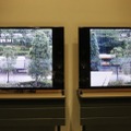 「SNC-VM772R」（左）と同社のFullHD解像度のカメラ（右）の実映像を使った比較。写真では分かりにくいが、街路樹の葉っぱや地面のタイトルなど4Kの方が鮮明に描写されていた（撮影：編集部）