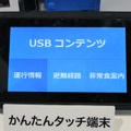 シンプルなボタンのタッチ端末から表示を切り替える。ソリューションとしての提供となるため、コンテンツや操作については個別に柔軟なシステム構築を行うことが可能となっている（撮影：防犯システム取材班）