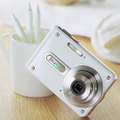 EXILIM CARD EX-S100のクレムホワイトモデル「EX-S100WE」。透光性セラミックスレンズを採用した光学2.8倍ズームレンズと有効320万画素CCDを装備