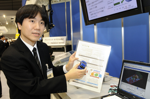 プラットフォーム技術本部 プロダクトソリューション技術統括部 IAサーバシステムセンターの津村昌祐氏。右下のモニターは、車体の衝突解析アプリケーションの実行結果のイメージを表示