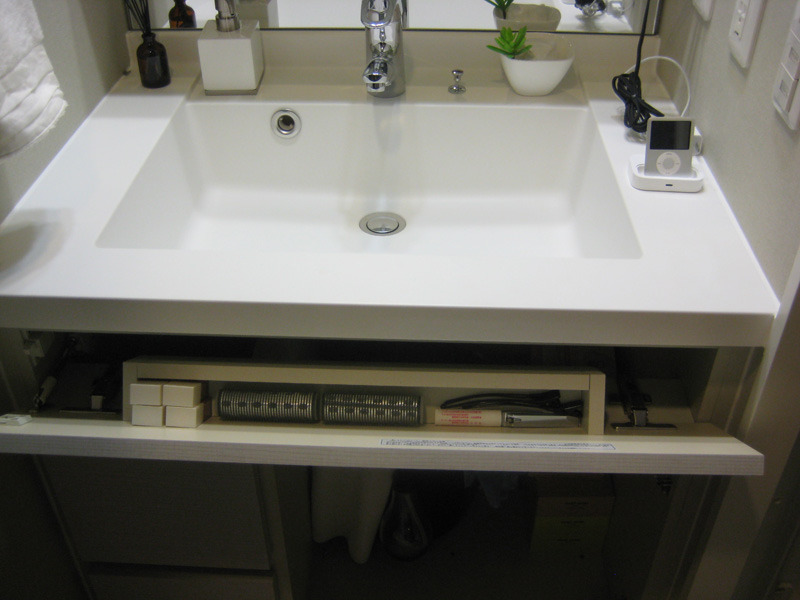 洗面台前のワンプッシュ式で開くスペースには、口紅やマニキュアなど、細々した化粧品を収納できる