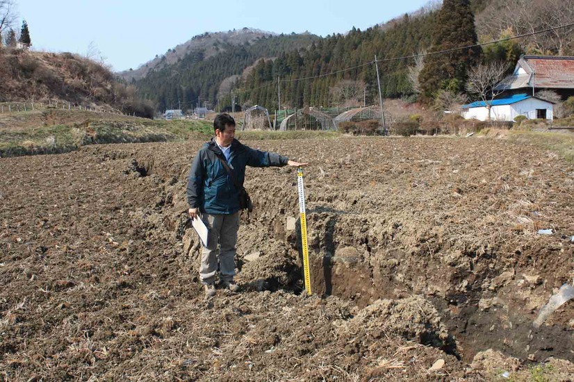  いわき市遠野町綱木，谷底面の水田を切る地表地震断層。北北西を望む。ほぼ垂直な断層面が開口亀裂に沿って露出する。（東京大学地震研究所）