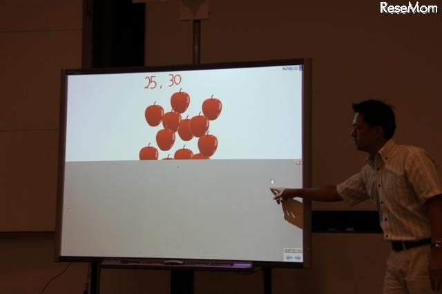【EDIX】電子黒板による実践的英語授業…暁星小学校 りんごを隠してたボードをずらすアクション。デジタルネイティブにはこのようなアナログ、もしくはリアルな動作のほうが訴求力が高い