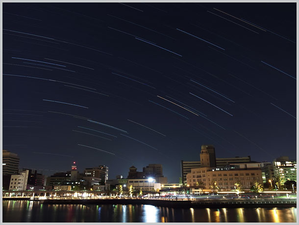 「インターバル合成」モードで星の光跡を写り込ませた風景写真のイメージ