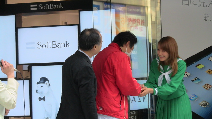 最初の購入者と握手するトリンドルさん