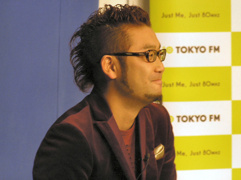 「Choppaya！」のDJを務める山蔭ヒーロ氏。TOKYO FMのアナログ放送で、「MAGICLA DASH！」のパーソナリティでもある。背後のブルーバックは、放送する際に映像上で背景にCGを合成するために用意されたもの