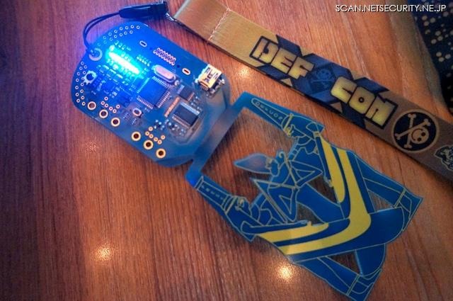 DEFCON 20 バッヂはエジプト神話のデザイン（写真はプレス用）で、赤外線通信やUSB接続が可能。このバッヂ自体も解読する競技になっている