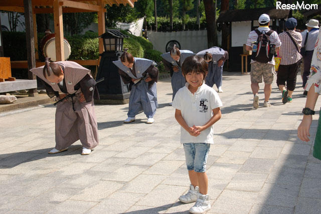 門の前で「がんばるぞ！」と黎くん