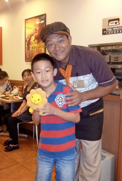 じゃんけん大会を勝ち抜いた男の子と記念撮影をする山口さん