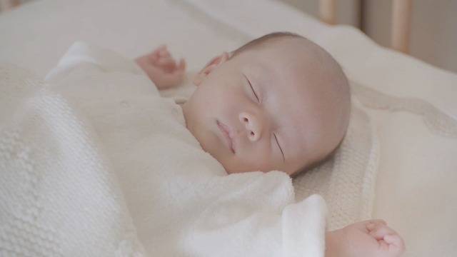 自宅のベビーベッドですやすやと眠る赤ちゃん