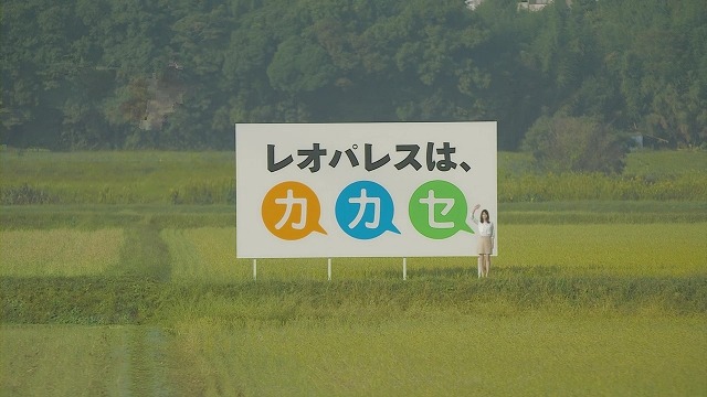 巨大看板の前で手を振る堀北