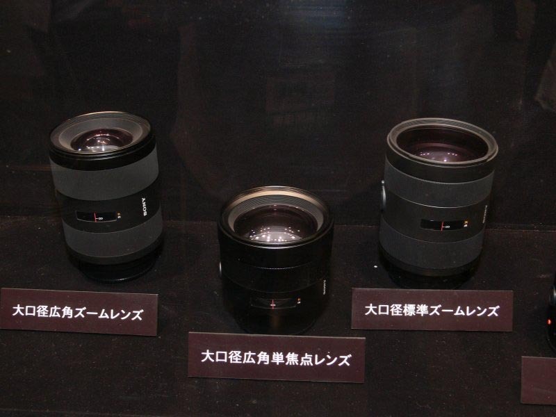 　ソニーブースのαシリーズ展示コーナーの一角には、α100の実機展示に加え、参考出品としてαシリーズのハイアマチュア向けモデルとフラッグシップモデルの2機種、および交換用レンズ8本が展示されている。