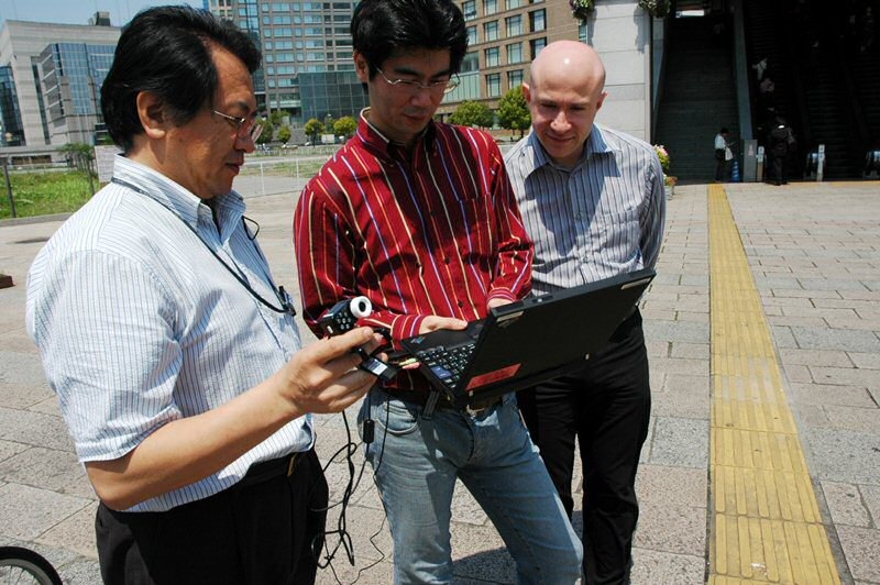 “動く歩道”前で一度通信状況をチェック。左からWiMAX推進室エンジニアの高崎一夫氏、小松直人氏、仏アルカテル・ルーセント社 First-Off Application ManagerのEric SALOMON氏