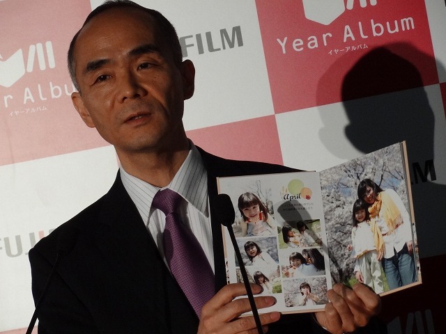 イメージング事業部の山元正人部長。手にするはYear Albumで作り上げたフォトブック。