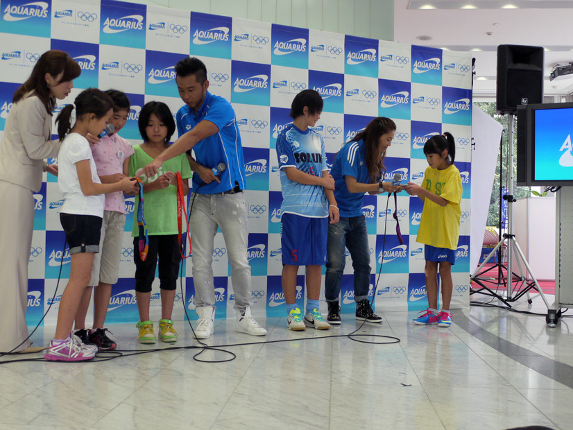 会場にかけつけた子供たちにメダルを見せる両選手