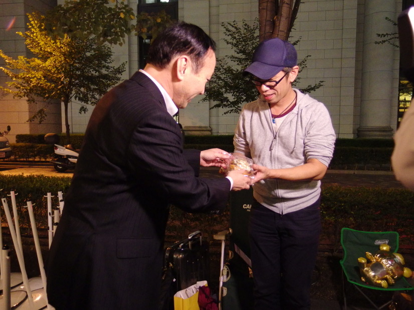 加藤社長が並ぶ人に差し入れ。一番乗りは都内の男性（9月19日）。