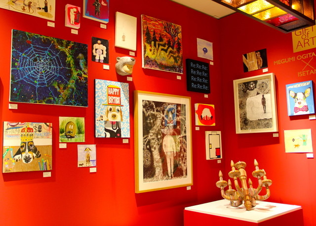 クリスマスを意識した赤い壁に展示される作品たち