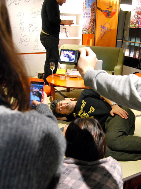 トーク後、酔っ払って座敷に寝転がる会田氏。と、それをケータイで撮る観客たち。