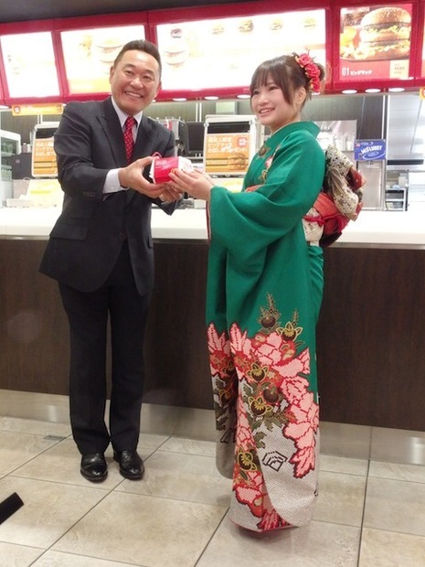 新成人にビッグマックを渡す松木氏