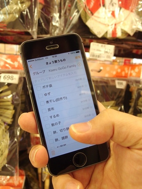 チェックリスト「きょう買うもの」を見ながらショッピングモールを歩く