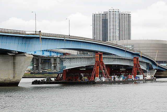 台船で晴海運河を移動する橋桁。既存の晴海通り延伸部をくぐり、目標の位置へと接近する