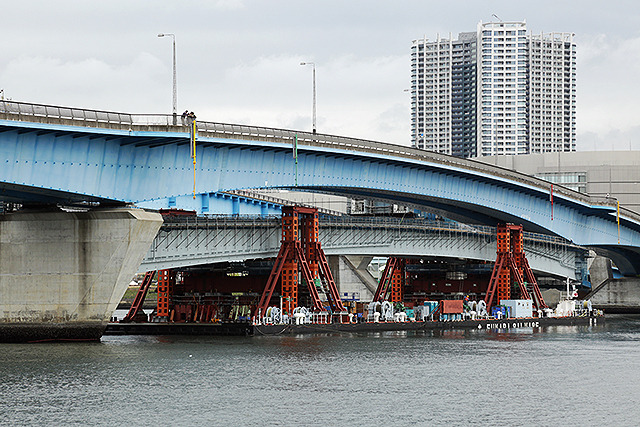 台船で晴海運河を移動する橋桁。既存の晴海通り延伸部をくぐり、目標の位置へと接近する