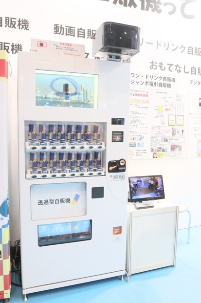 日本マシンサービスのブースに展示されていた「防犯自販機」。上部にあるボックスの中にネットワークカメラが内蔵されている。他にも防災用途を想定したサイネージ付きの自販機なども展示されていた（撮影：編集部）