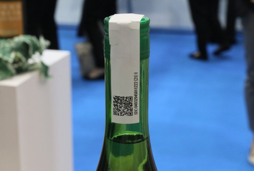 同製品は酒瓶のフタ部分に貼り付けて使用する。紙をベースにしているため、無理に剥がそうとしたり、フタを開けると紙が破れ、開封されたかの目印となる（撮影：防犯システム取材班）