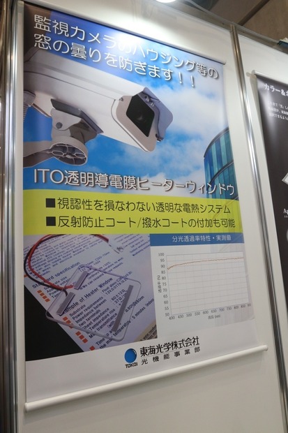 「ITO透明導電膜 ヒーターウィンドウ」の説明板。ハウジングでレンズ部分がのぞく窓部分にはめ込んで使用する（撮影：防犯システム取材班）