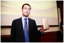 1億台めを手にする同社ハンドセットプロダクトラインのトップである何剛氏