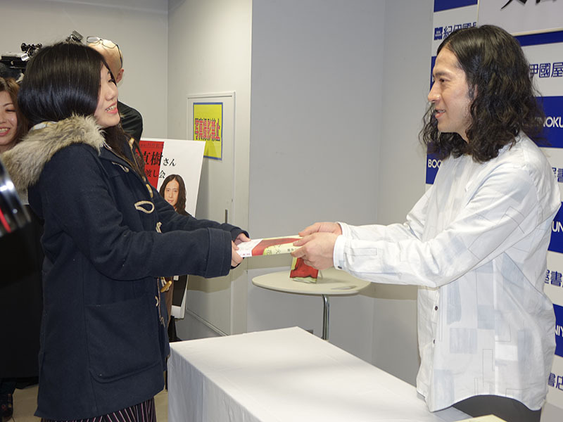 ファンに小説を手渡すピースの又吉直樹（写真は3月12日に行われたサイン会のもの）【写真：田中】